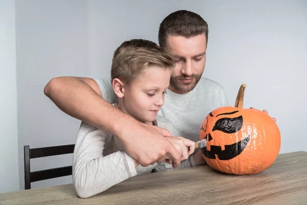 Far och son med halloween pumpa — Stockfoto