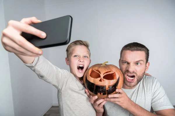 Far och son med halloween pumpa — Stockfoto