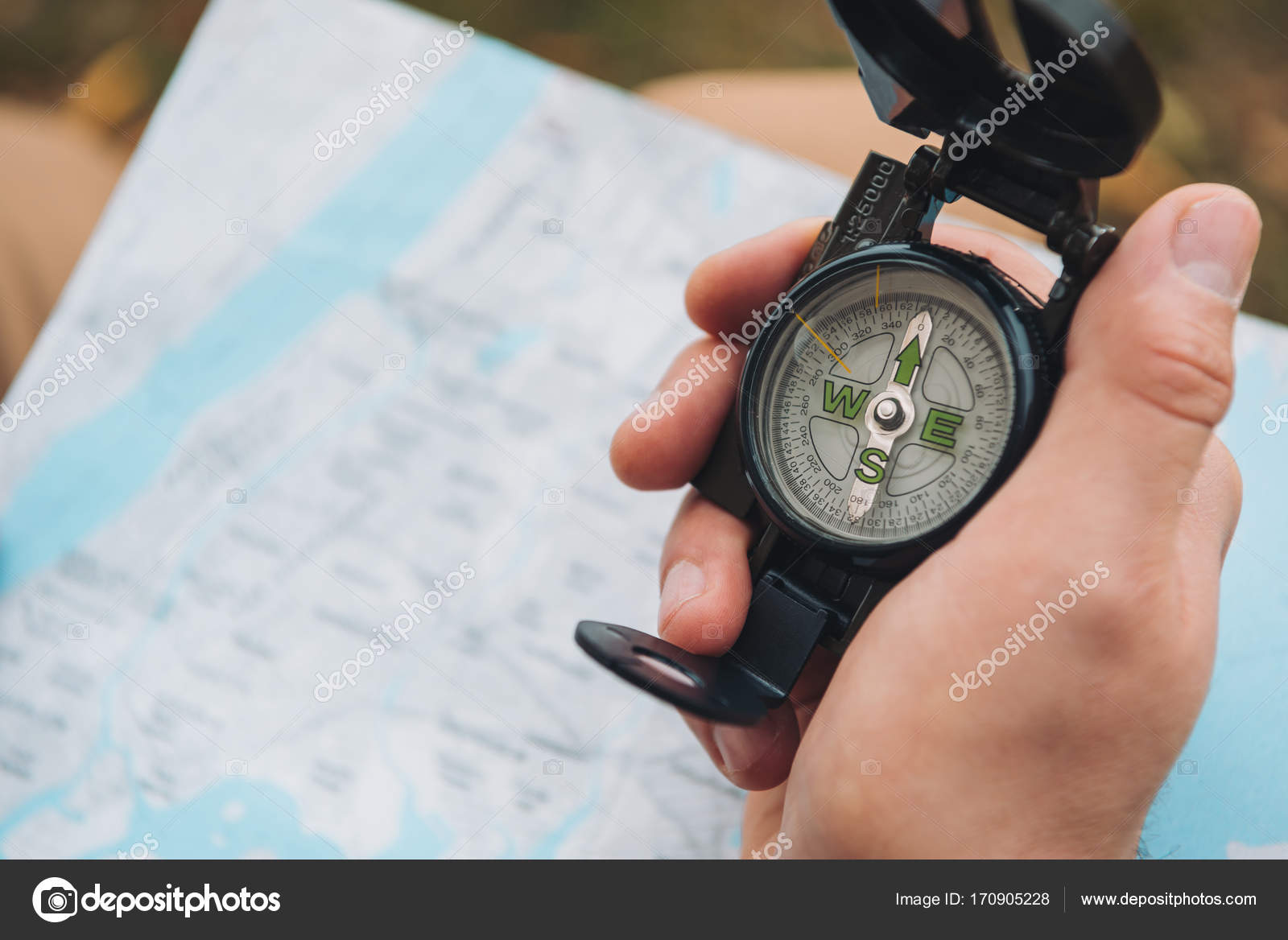Tourist holding compass in hand Stock Photo by ©DmitryPoch 170905228