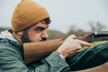 Handsome man aiming with gun clipart