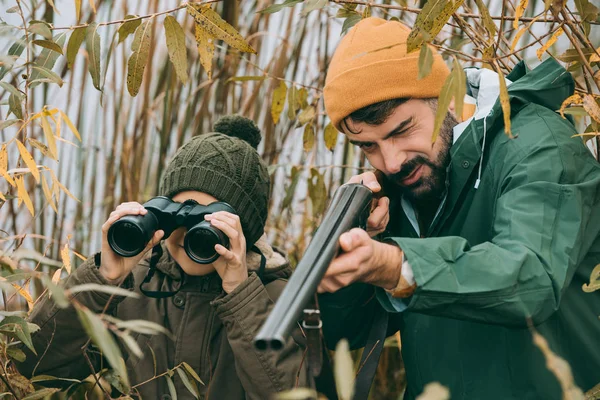 Far som syftar till att djur med pistol — Stockfoto