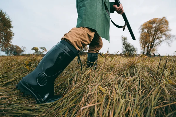 Cazador va con el arma en el campo — Foto de Stock