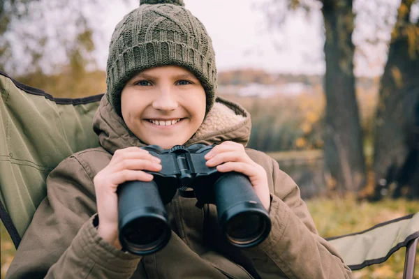 Kid looking at camera and holding binoculars — Free Stock Photo