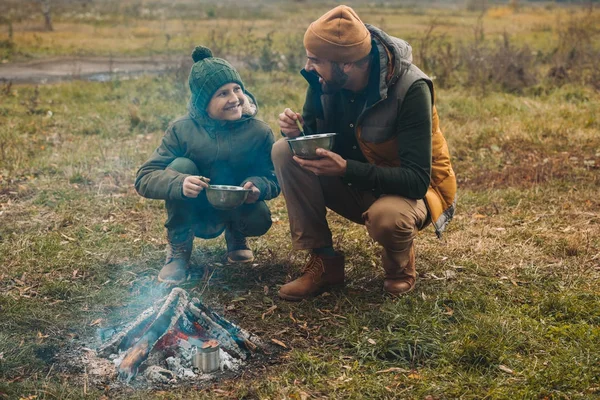 Батько і син їдять їжу на природі — стокове фото