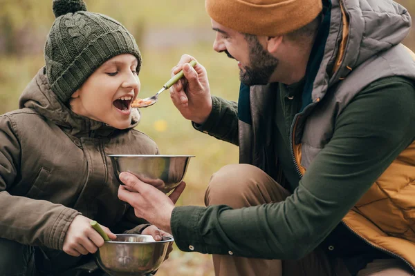 Father giving spoon with beans to son — Stock Photo, Image