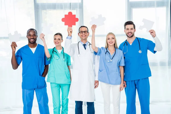 Médicos segurando peças de puzzle — Fotografia de Stock