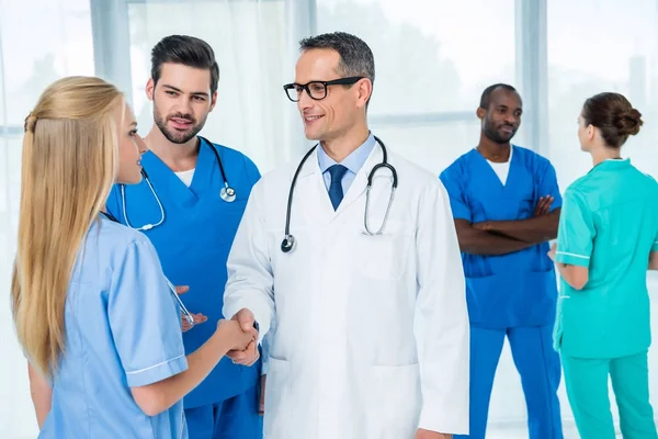 Allgemeinmediziner schabt Hand der Krankenschwester — Stockfoto