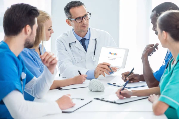 Médicos conversando e olhando para tablet — Fotografia de Stock