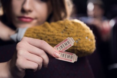 cropped view of woman holding two cinema tickets clipart