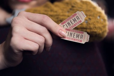 cropped view of woman holding two cinema tickets clipart