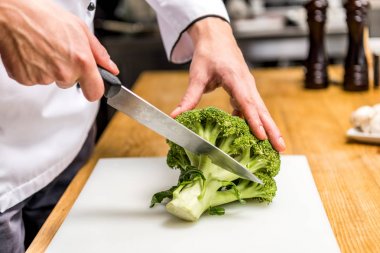 cropped image of chef cutting broccoli clipart