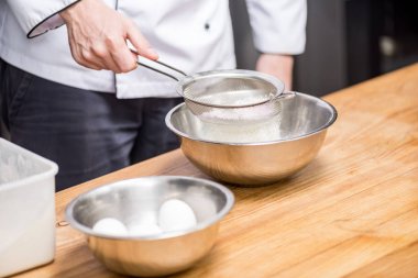 cropped image of chef holding sieve with flour clipart