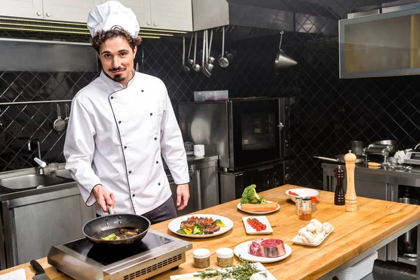 Chef Kok Frituren Groenten Camera Kijken — Stockfoto