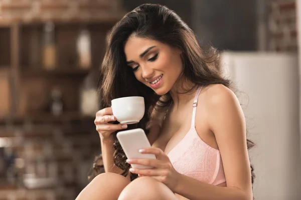 Όμορφο Χαμόγελο Σέξι Κορίτσι Στο Σουτιέν Πίνοντας Καφέ Και Χρησιμοποιώντας Εικόνα Αρχείου