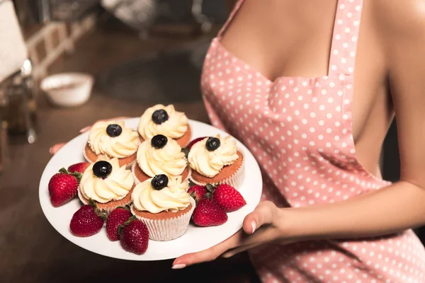 Beskåret Skud Sexet Pige Forklæde Bedrift Plade Med Cupcakes Jordbær Royaltyfrie stock-fotos