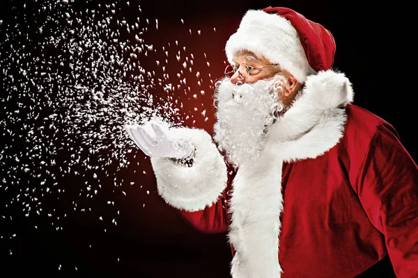 Papá Noel soplando copos de nieve — Stock Photo