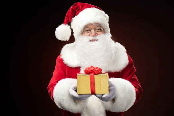Санта-Клаус с подарочной коробкой в руке — стоковое фото
