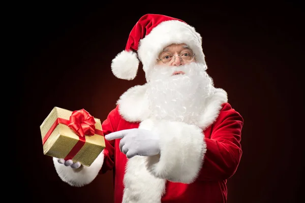 Santa Claus pointing on gift box — Stock Photo