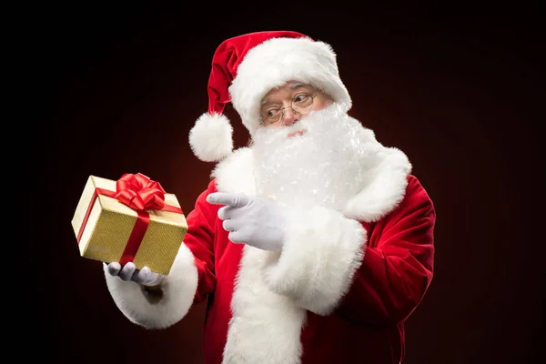 Santa Claus apuntando a la caja de regalo - foto de stock