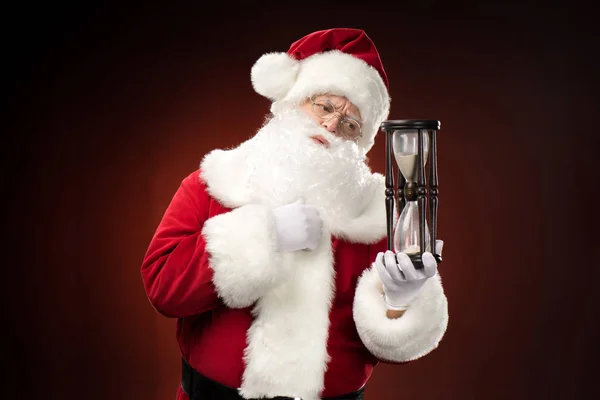 Santa Claus looking at hourglass — Stock Photo