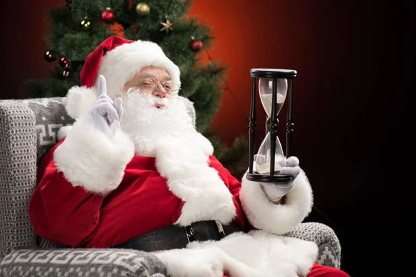 Santa Claus sentado con reloj de arena - foto de stock
