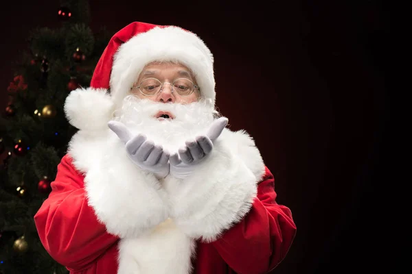 Santa Claus blowing snowflakes — Stock Photo