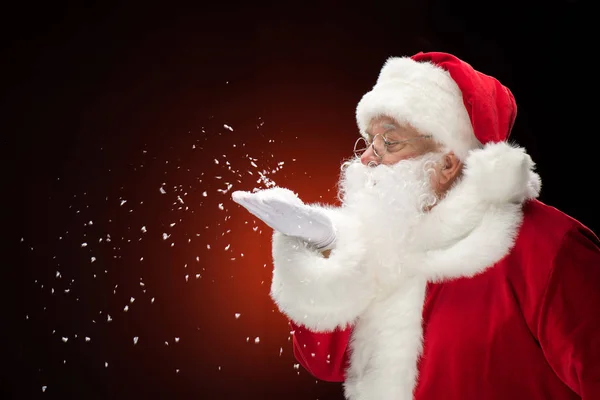 Santa Claus blowing snowflakes — Stock Photo