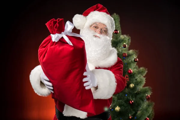 Happy Santa Claus showing big sack — Stock Photo