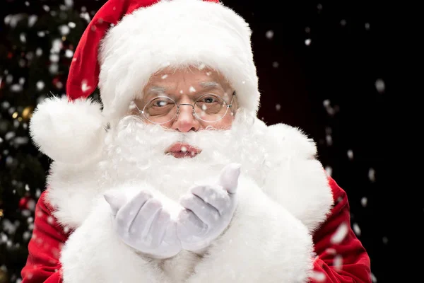 Papá Noel soplando copos de nieve - foto de stock