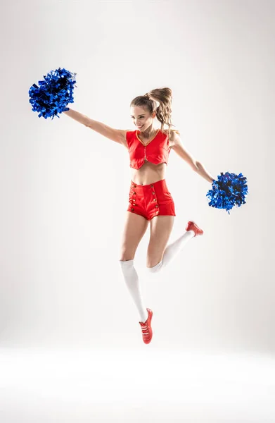 Cheerleader jumping with pom-poms — Stock Photo