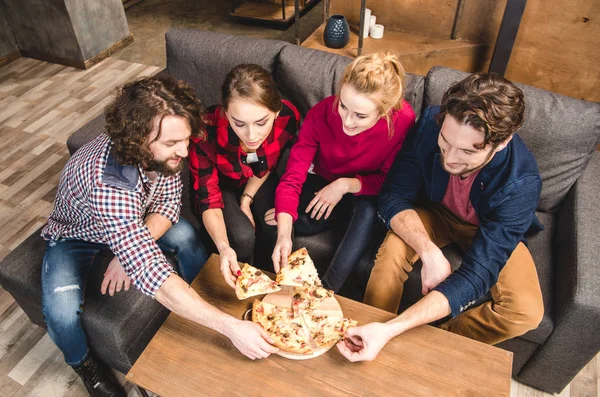 Lächelnde Freunde beim Pizza essen — Stockfoto