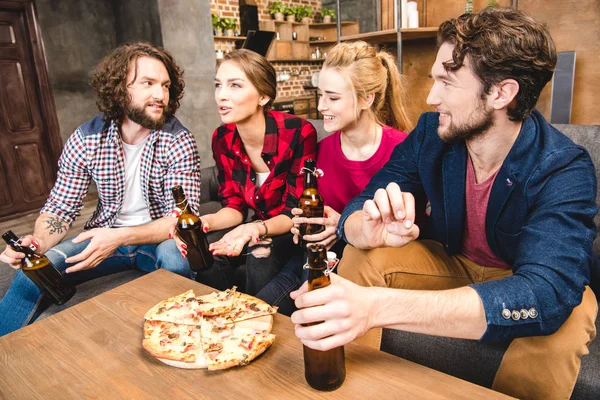 Friends drinking beer and eating pizza — Stock Photo