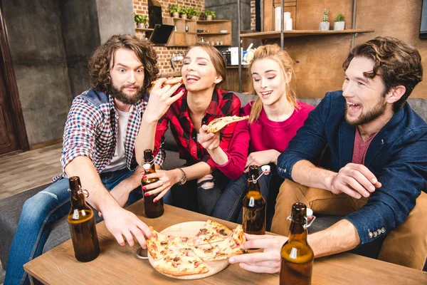 Друзі п'ють пиво і їдять піцу — стокове фото