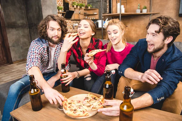 Amigos bebendo cerveja e comendo pizza — Fotografia de Stock