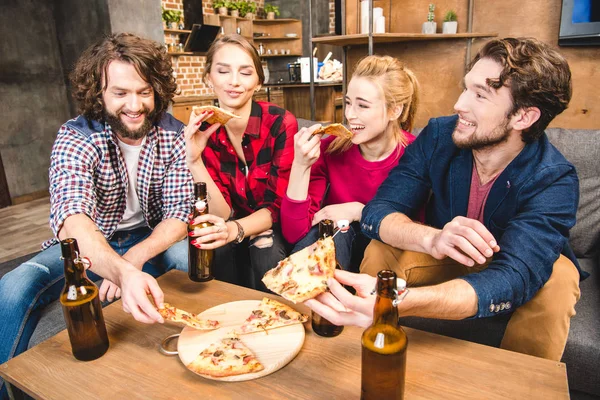 Friends drinking beer and eating pizza — Stock Photo