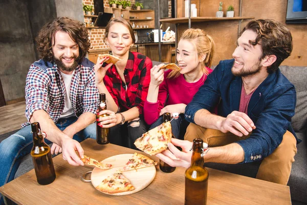 Amigos bebiendo cerveza y comiendo pizza - foto de stock