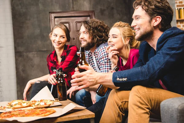 Friends drinking beer and eating pizza — Stock Photo