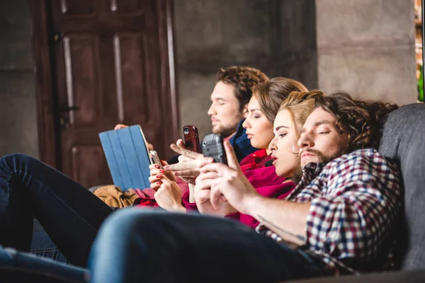 Serious friends using digital devices — Stock Photo