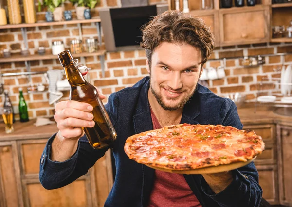 Человек с пивом и пиццей — стоковое фото