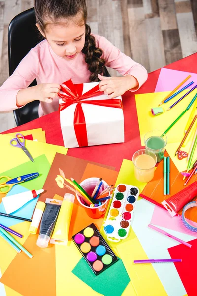 Schoolchild wrapping gift box — Stock Photo