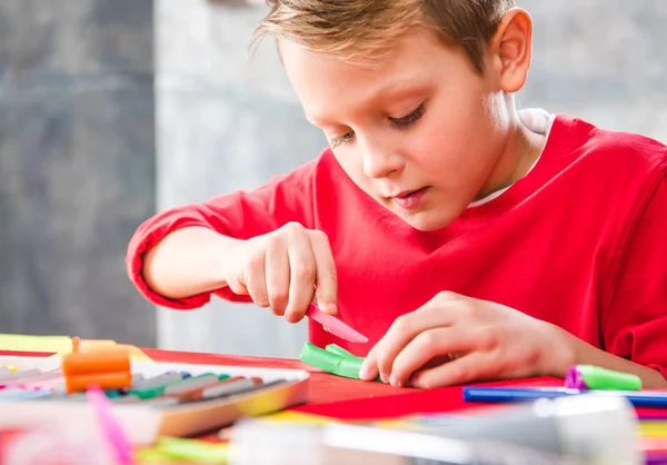 Écolier couper la plasticine — Photo de stock