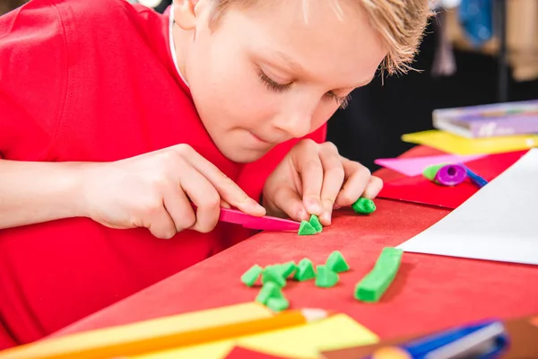 Schulkind schneidet Knetmasse — Stockfoto