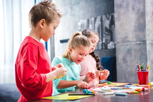 Schoolchildren playing with plasticine — Stock Photo