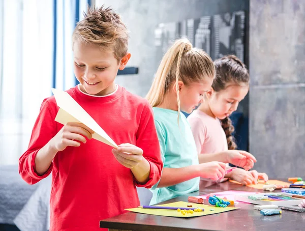 Enfant jouant avec un avion en papier — Photo de stock