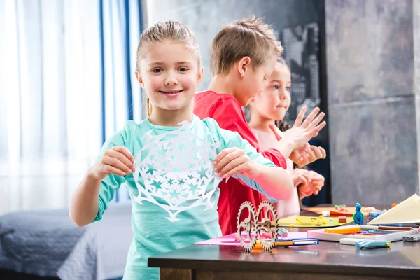 Kid cutting snowflake from paper — Stock Photo