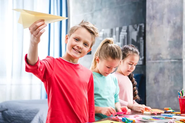 Enfant jouant avec un avion en papier — Photo de stock