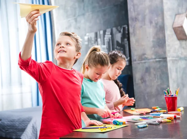 Niño jugando con avión de papel - foto de stock