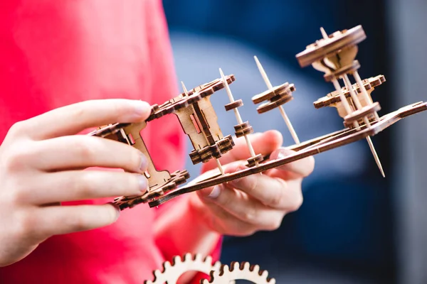 Kid holding wooden gear toy — Stock Photo