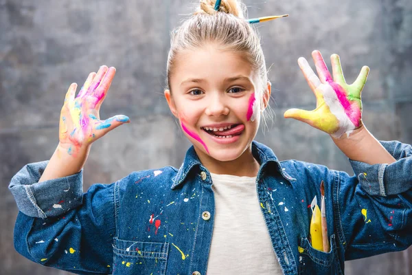 Schoolgirl artist with painted face — Stock Photo