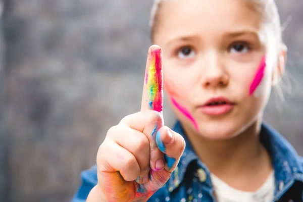 Schoolgirl artist with painted face — Stock Photo